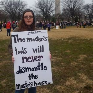 Perry Holmes holding sign at a protest in DC: "The master's tools will never dismantle the master's house" from Audre Lorde